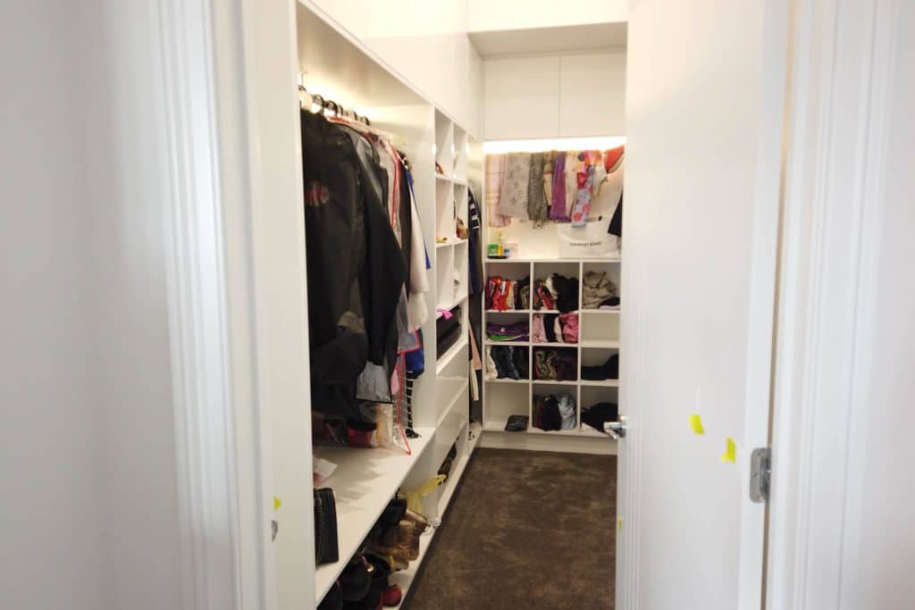 Neatly organised walk-in wardrobe space.